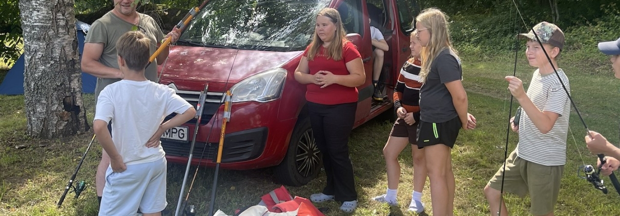 Noored kalalaagris Mõniste järve ääres õngede ja päästevestidega